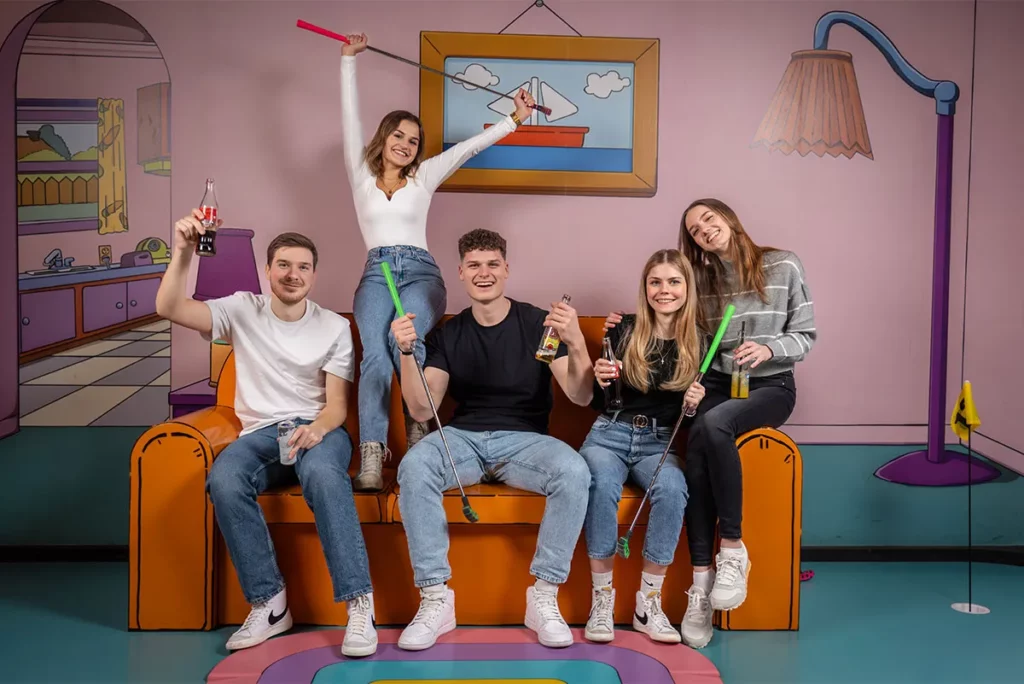 Gruppe sitzt auf Couch in Indoor-Areal Hollywood Golf