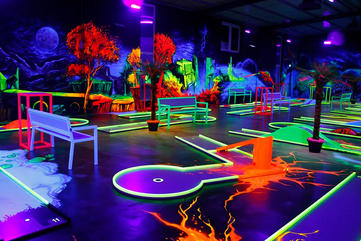 Schwarzlicht Minigolf mit fantasievoller Landschaft und Lichtakzenten