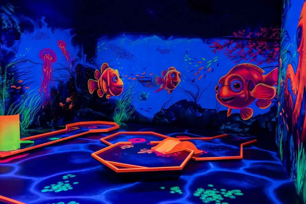 Schwarzlicht-Minigolfbahn mit Korallen und Fischen